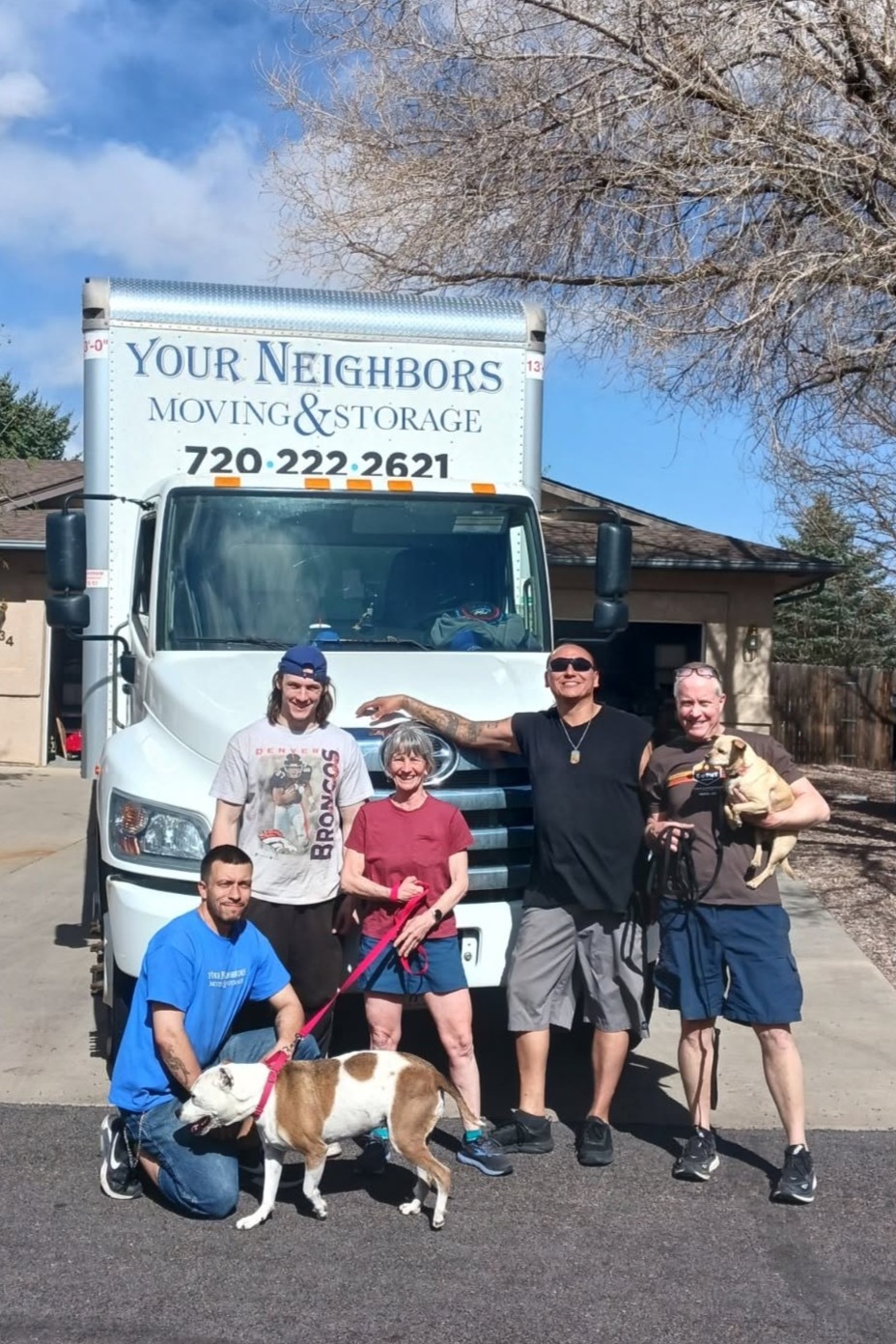 Customers, movers, and their dogs in front of the truck